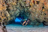 Diver In Coral Cavern. Cayman Islands