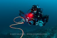 Underwater photographer with red light. Maldives.