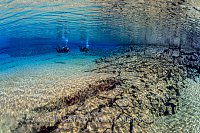 Divers In Blue Lagoon, Silfra, Iceland.