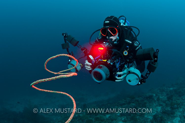 Underwater photographer with red light. Maldives.