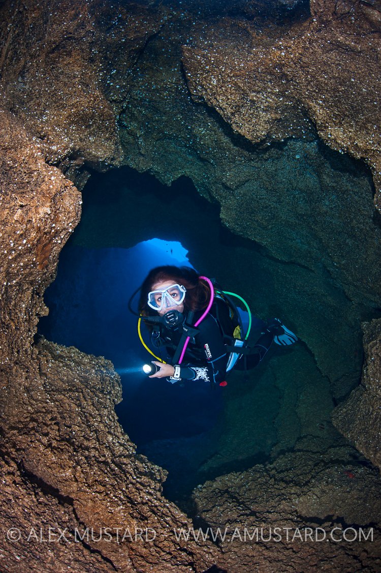 Diver Explores Cave. Sardinia, Italy.