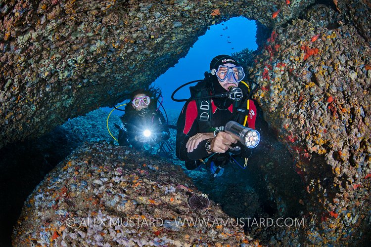 Divers In Boulders. Italy